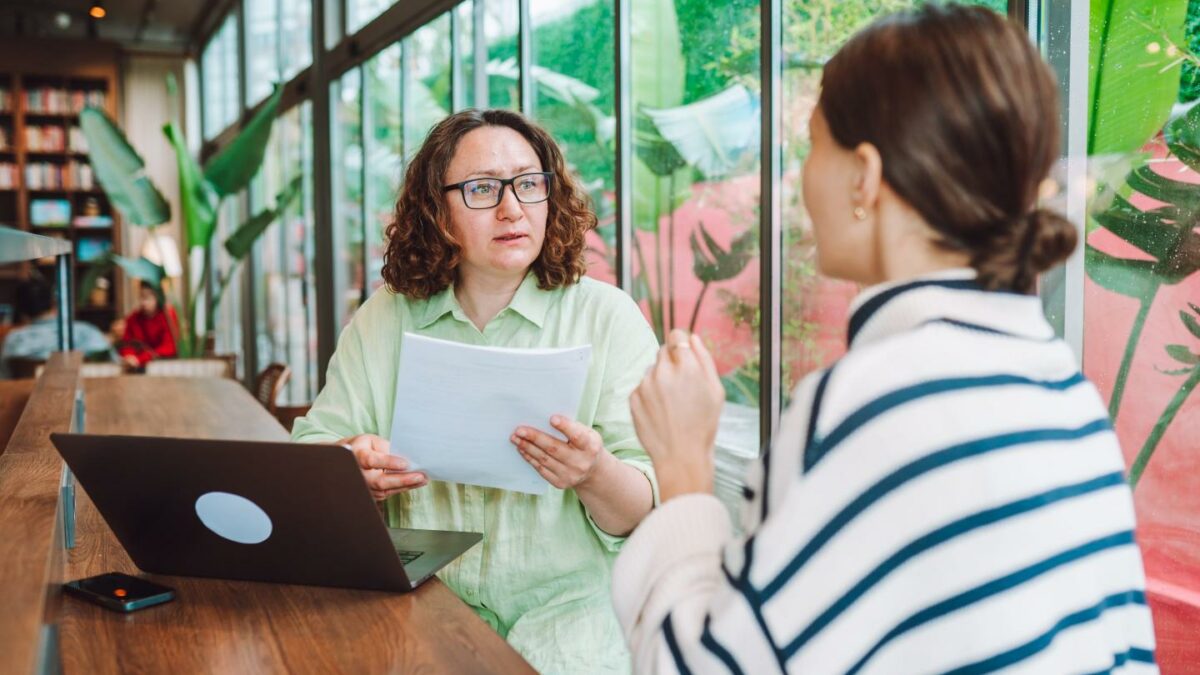 Boss sits with worker to discuss raise at office